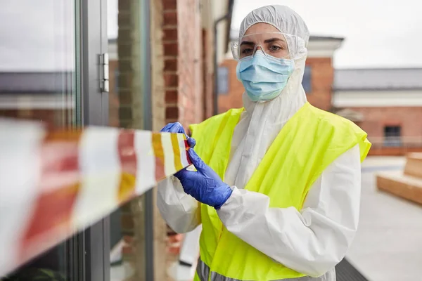 Trabajador de la salud sellando la puerta con cinta de precaución —  Fotos de Stock