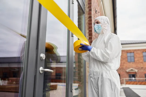 Trabajador de la salud sellando la puerta con cinta de precaución — Foto de Stock