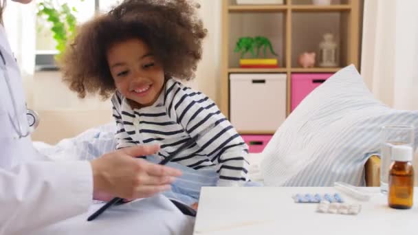 Médico com computador tablet e menina doente na cama — Vídeo de Stock