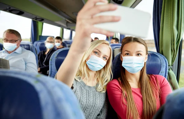 Kobiety w maskach medycznych biorąc selfie w autobusie podróży — Zdjęcie stockowe