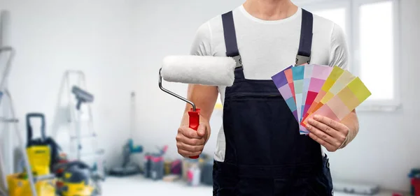 Close up of painter with roller and color charts — Stock Photo, Image