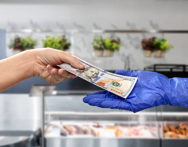 Close-up van de hand in medische handschoen geven geld — Stockfoto