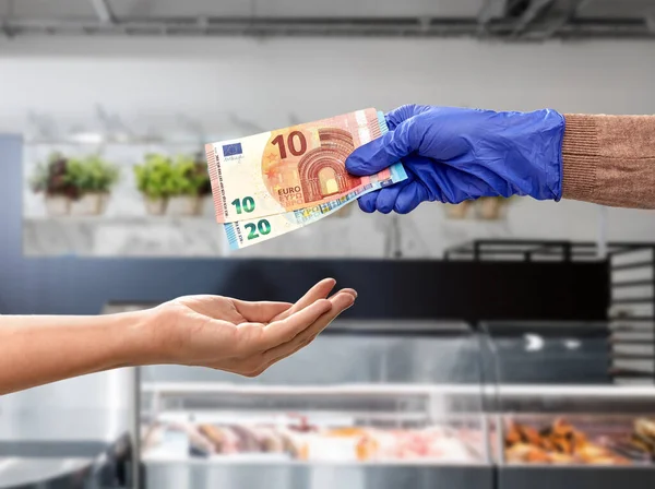 Nahaufnahme der Hand in medizinischen Handschuhen für Geld — Stockfoto