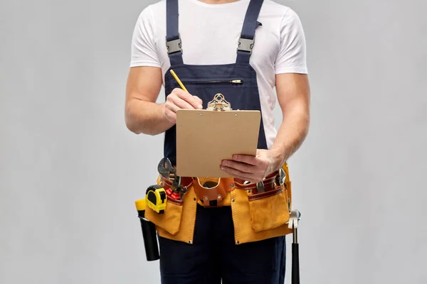 Builder with clipboard, pencil and working tools — Stock Photo, Image