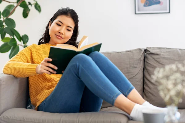 Asiática joven leyendo libro en casa — Foto de Stock