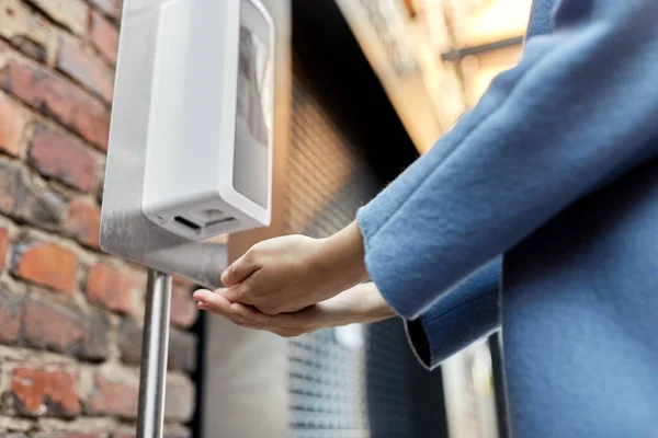 Close up of woman at dispenser with hand disanitizer — стоковое фото