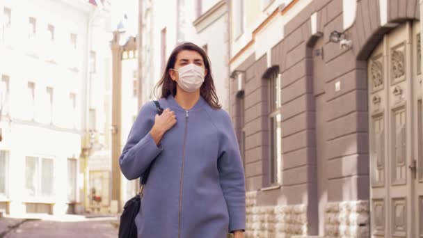 Frau mit medizinischer Maske läuft durch die Stadt — Stockvideo