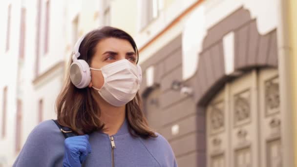 Vrouw met medisch masker en handschoenen in de stad — Stockvideo