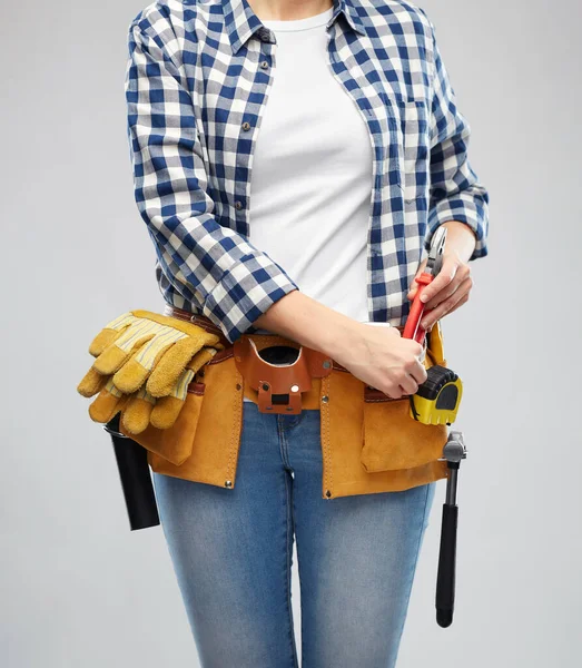 Женщина или строитель с рабочими инструментами на поясе — стоковое фото