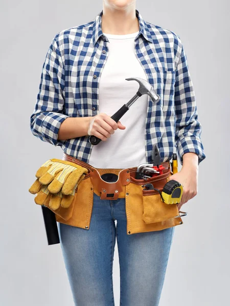 Mujer con martillo y herramientas de trabajo en el cinturón — Foto de Stock