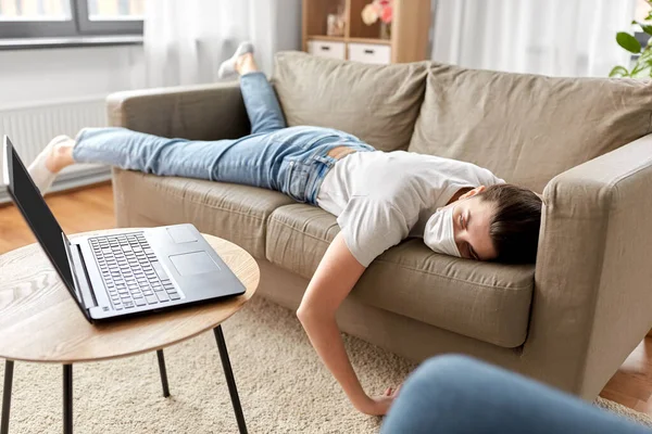 Больная скучающая женщина с ноутбуком лежит на диване дома — стоковое фото