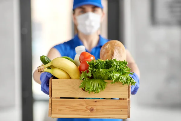 Mujer de entrega en mascarilla con comida en caja — Foto de Stock