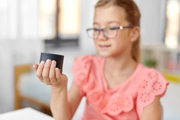 Studente ragazza utilizzando intelligente altoparlante a casa — Foto Stock