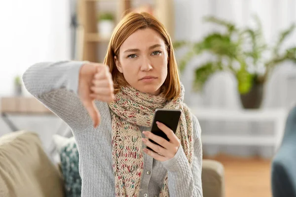 Nemocná žena s chytrým telefonem ukazující palce dolů — Stock fotografie