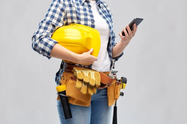 Женщина или строитель с телефоном и рабочими инструментами — стоковое фото