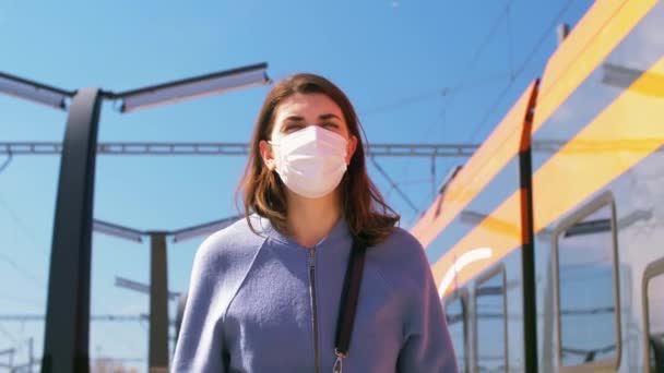 Donna in maschera passeggiando lungo la stazione ferroviaria vuota — Video Stock