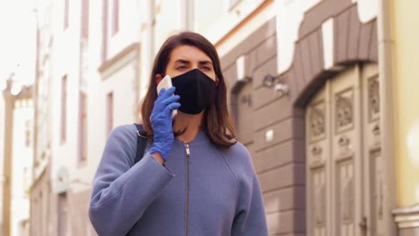 Yüz maskeli kadın şehirdeki akıllı telefondan arıyor. — Stok video