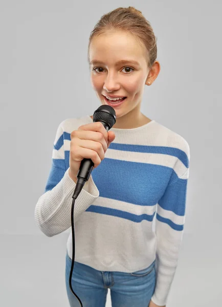 Lachende tiener meisje met microfoon zingen — Stockfoto