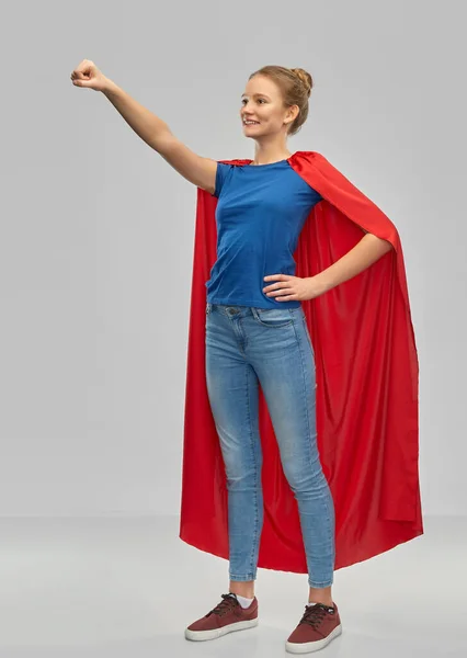 Glimlachende tiener meisje in rode superheld cape — Stockfoto