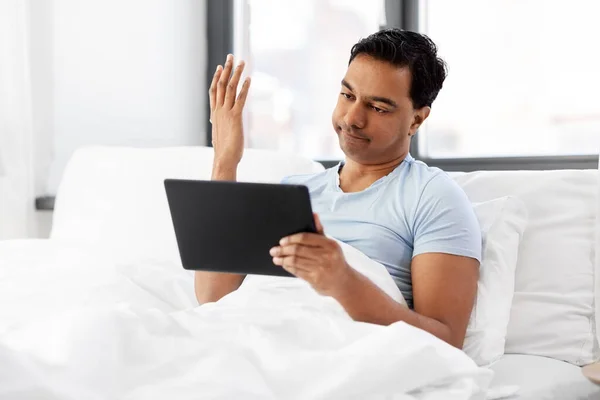 Hombre indio con tableta pc en la cama en casa —  Fotos de Stock
