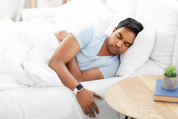 印度男子与聪明的手表睡在床上 — 图库照片