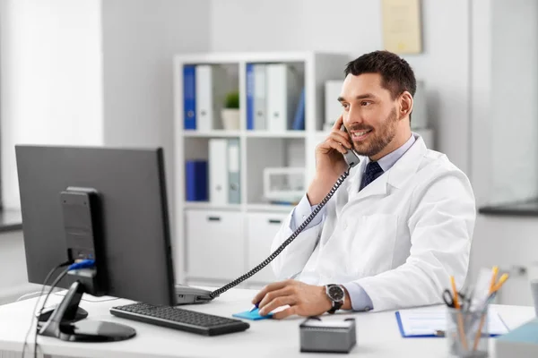 Médecin masculin appelant sur le téléphone de bureau à l'hôpital — Photo