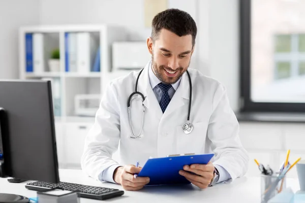 Sorridente médico masculino com área de transferência no hospital — Fotografia de Stock