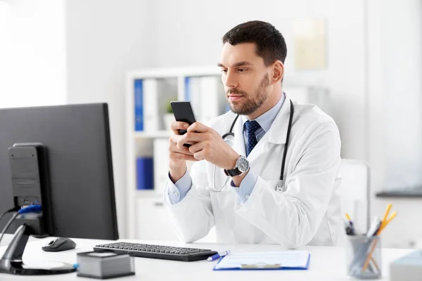 Médico masculino com smartphone no hospital — Fotografia de Stock