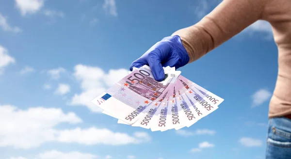 Close up de mão na luva médica com dinheiro — Fotografia de Stock