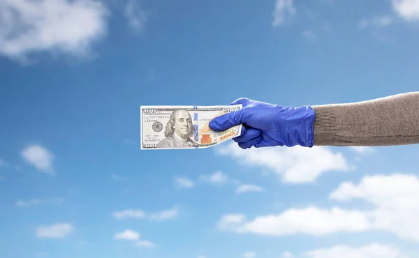 Zblízka ruky v lékařské rukavici s penězi — Stock fotografie