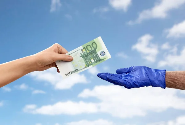 Vicino di mano in guanto medico dando soldi — Foto Stock