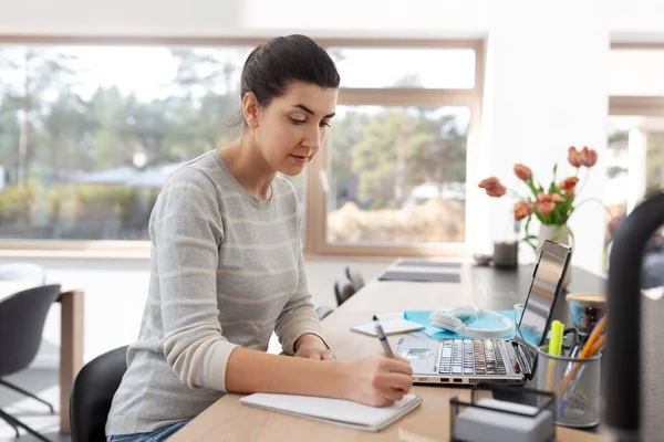 Mujer joven con el ordenador portátil que trabaja en casa oficina — Foto de Stock