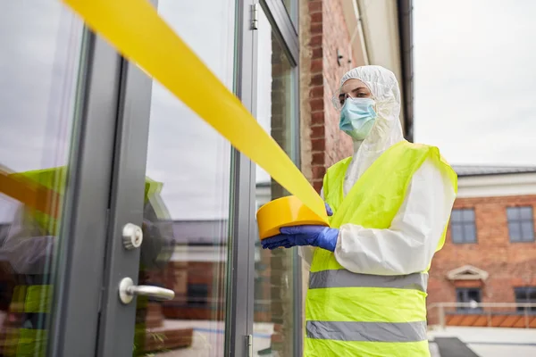 Trabajador de la salud sellando la puerta con cinta de precaución — Foto de Stock