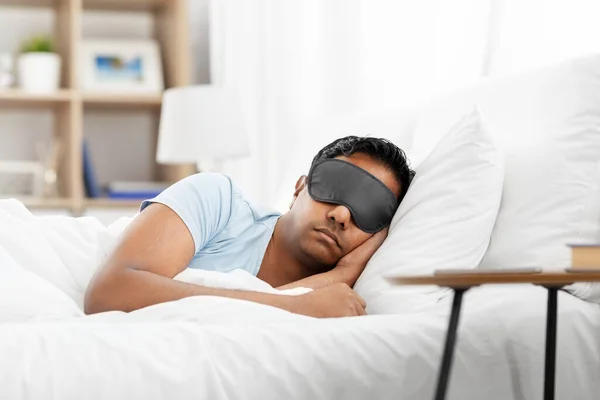 Hombre indio en máscara de ojos durmiendo en la cama en casa — Foto de Stock