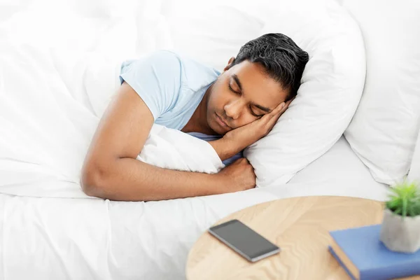 indian man sleeping in bed at home