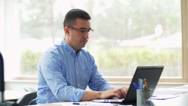 Vermoeide man met laptop aan het werk op kantoor — Stockvideo