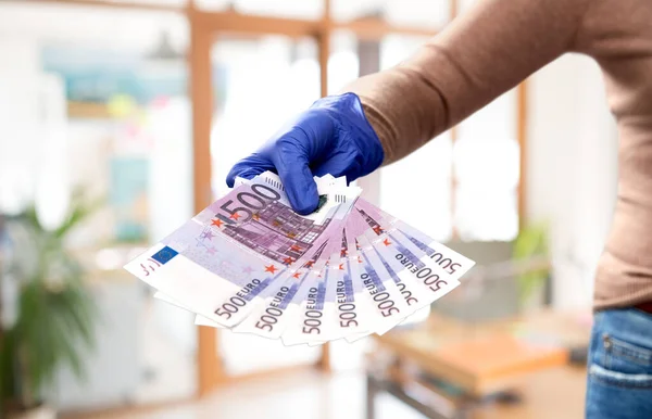 Крупним планом рука в медичній рукавичці з грошима — стокове фото