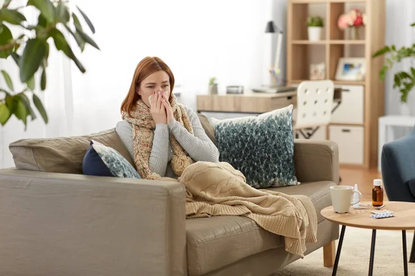 Sick woman blowing nose in paper tissue at home — Stock Photo, Image