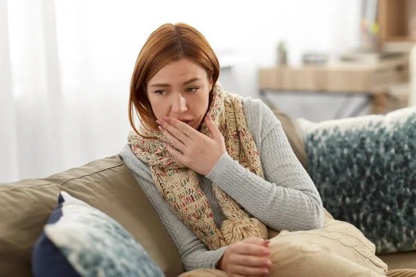 Zieke vrouw in sjaal hoesten thuis — Stockfoto