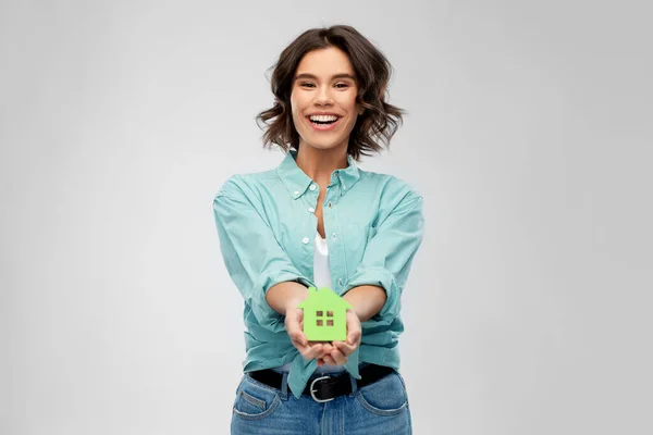 Lächelnde junge Frau mit grünem Haus — Stockfoto