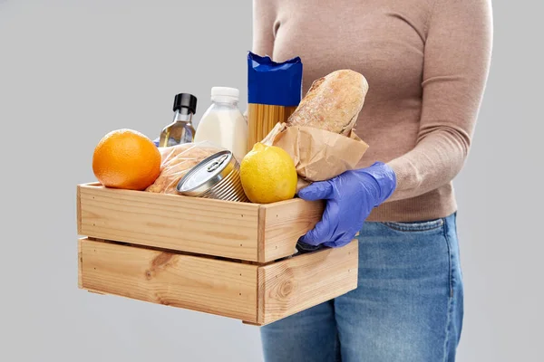 Mujer en guantes con comida en caja de madera —  Fotos de Stock