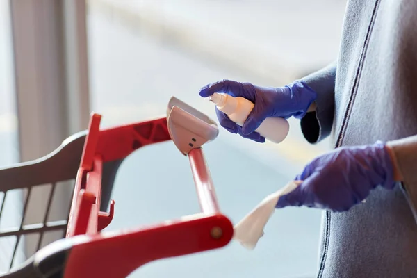Woman cleaning shopping cart handle with sanitizer — Stock Photo, Image