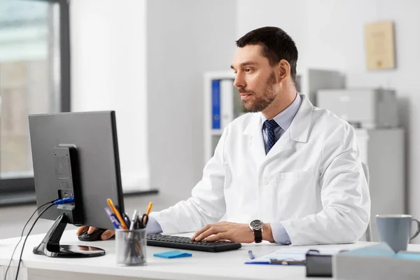 Médico masculino com computador que trabalha no hospital — Fotografia de Stock