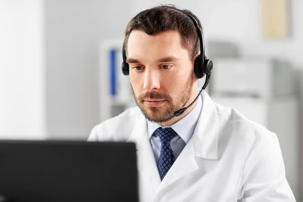 Male doctor with computer and headset at hospital — Stock Photo, Image