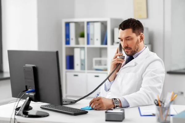 Doctor de sex masculin apelând la telefon de birou la spital — Fotografie, imagine de stoc