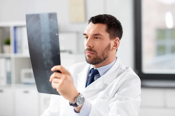 Médico varón con radiografía de columna vertebral en el hospital —  Fotos de Stock