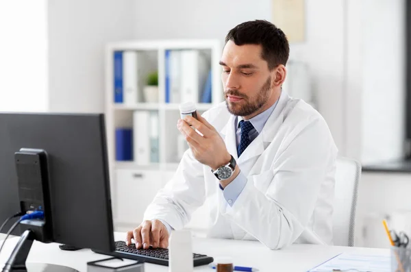 Médico masculino com medicina e computador no hospital — Fotografia de Stock