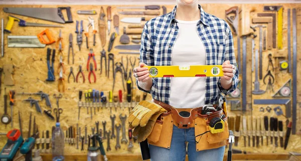 Kvinna byggare med nivå och arbetsredskap på bälte — Stockfoto