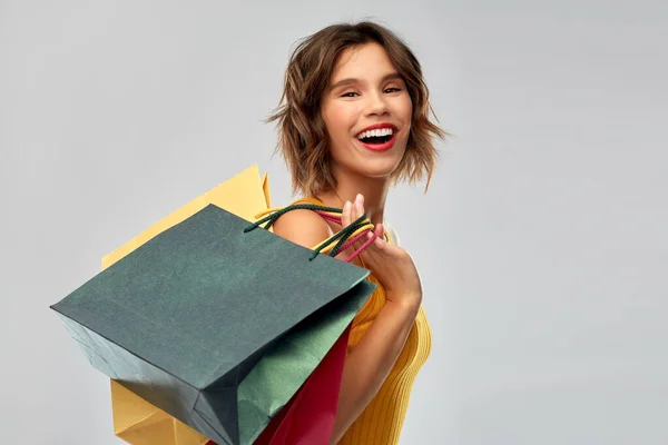 Feliz joven sonriente con bolsas de compras —  Fotos de Stock