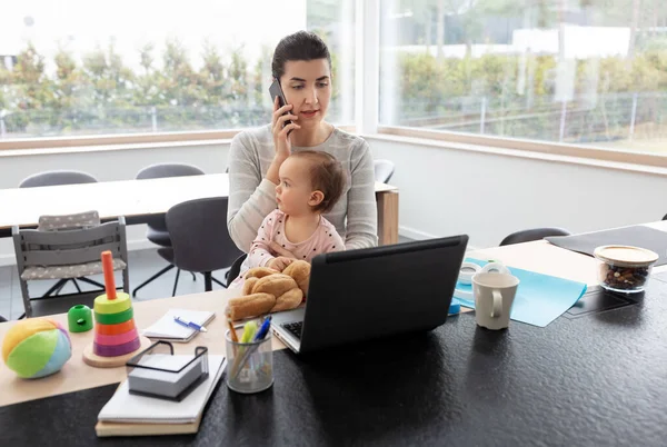 Madre con el bebé trabajando en el ordenador portátil en la oficina en casa — Foto de Stock